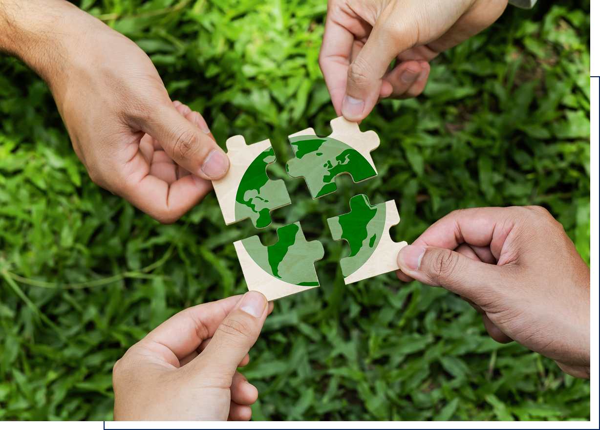 Hands assembling Earth puzzle over grass